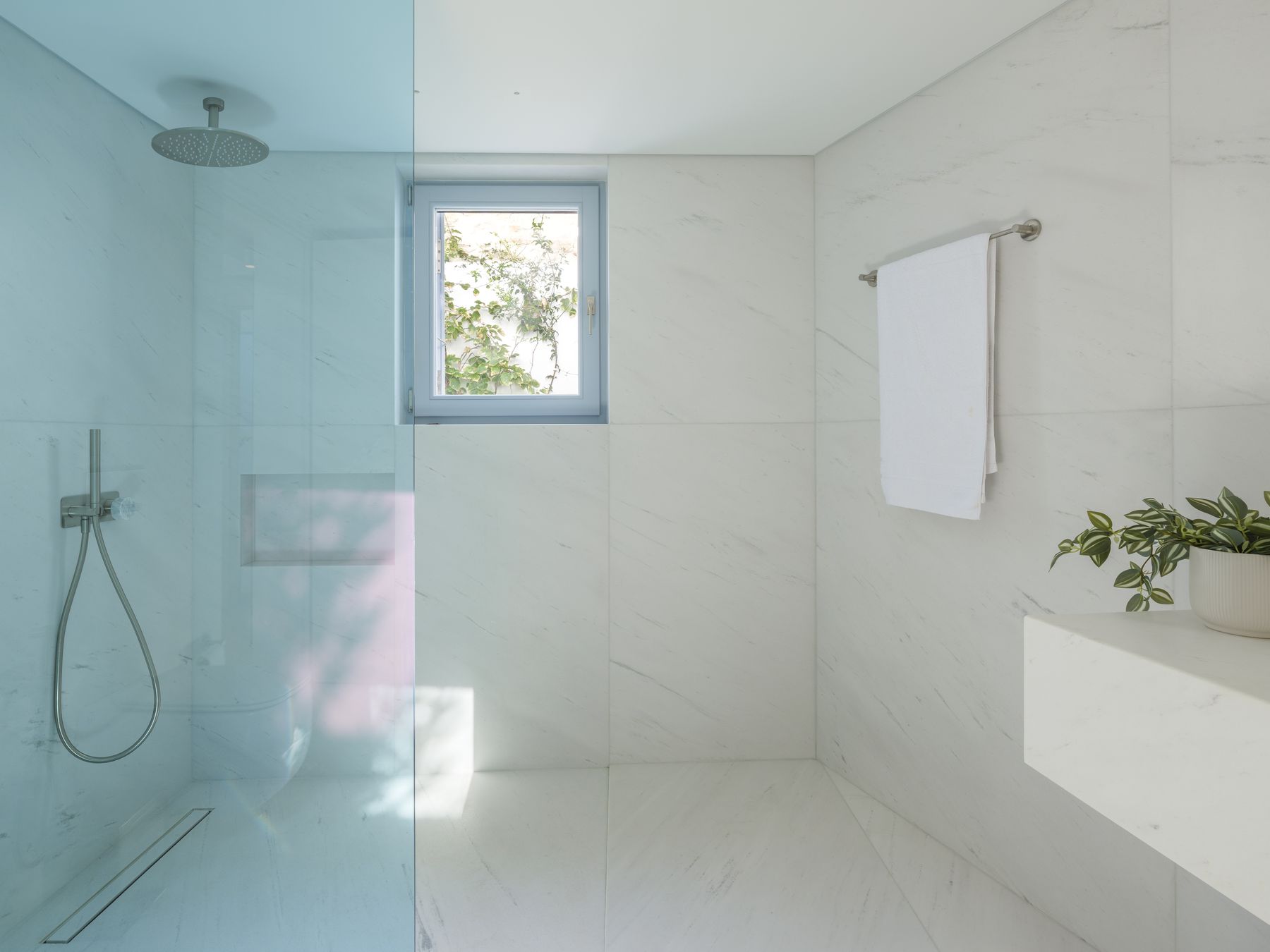 Marble bathroom with blue glass walk-in shower